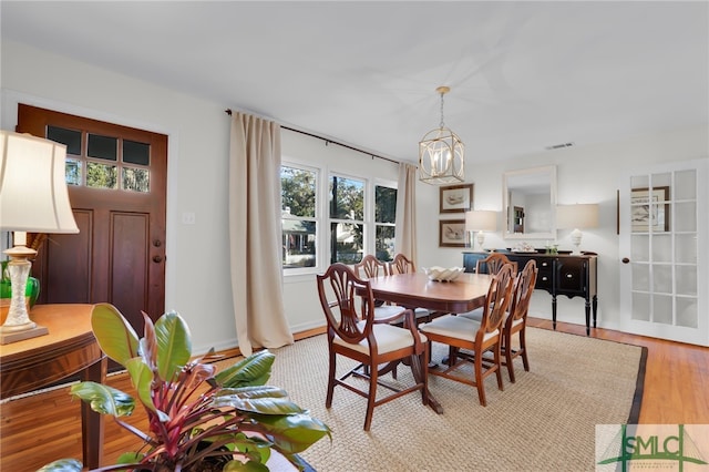 dining space featuring light hardwood / wood-style flooring and a notable chandelier