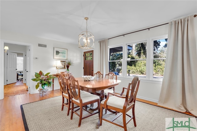 dining space featuring light hardwood / wood-style flooring and a notable chandelier