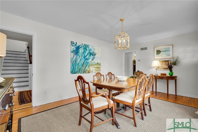 dining area with a chandelier and light hardwood / wood-style flooring