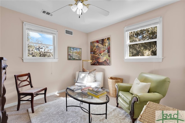 living area with plenty of natural light, ceiling fan, and light colored carpet