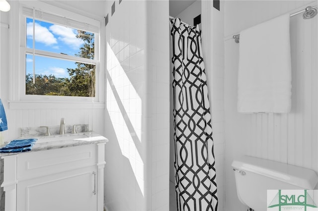 bathroom with curtained shower, vanity, and toilet