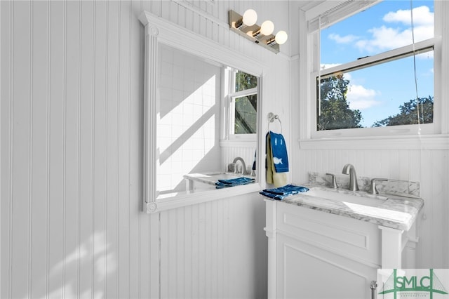 bathroom with vanity and wood walls