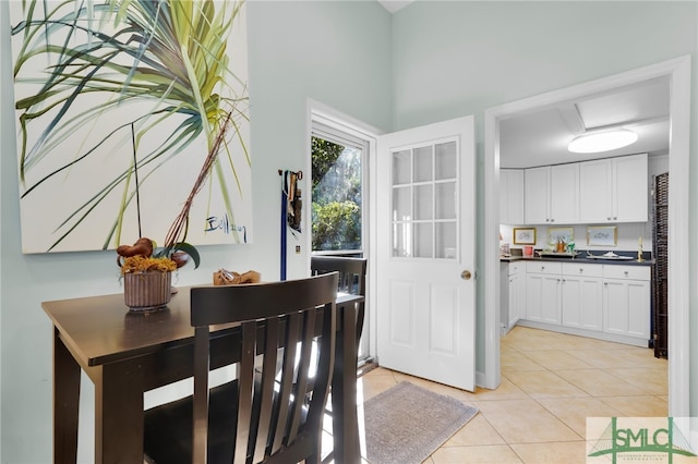 dining room with light tile patterned floors and a high ceiling