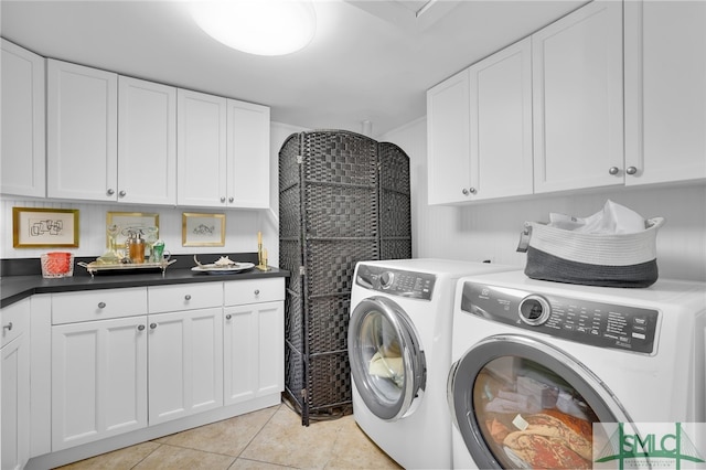 laundry room featuring cabinets, light tile patterned flooring, and washer and dryer