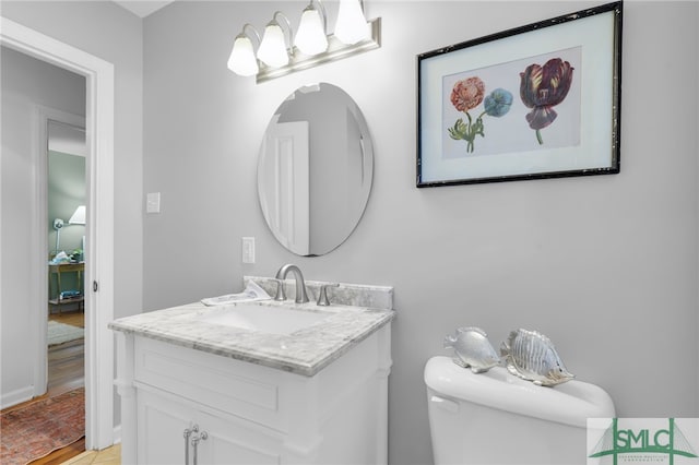 bathroom featuring vanity, wood-type flooring, and toilet