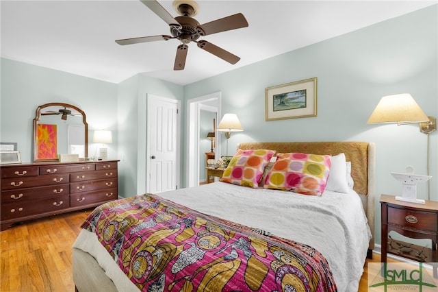 bedroom featuring ceiling fan, light wood-type flooring, and a closet