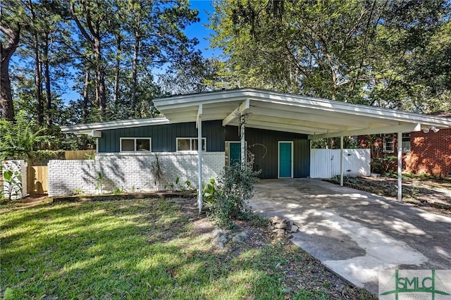 ranch-style home featuring a carport and a front yard