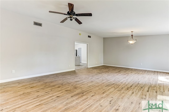 empty room with ceiling fan, light hardwood / wood-style floors, and vaulted ceiling