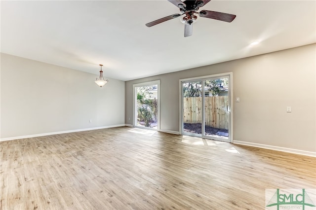 empty room with ceiling fan and light hardwood / wood-style flooring