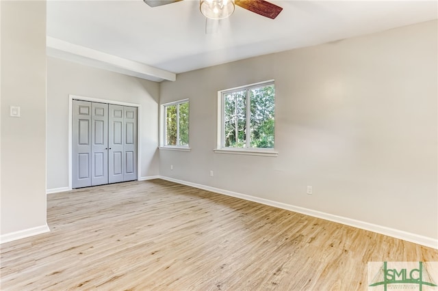 unfurnished bedroom featuring ceiling fan, light hardwood / wood-style floors, and a closet