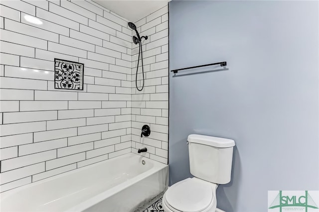 bathroom featuring tiled shower / bath combo and toilet