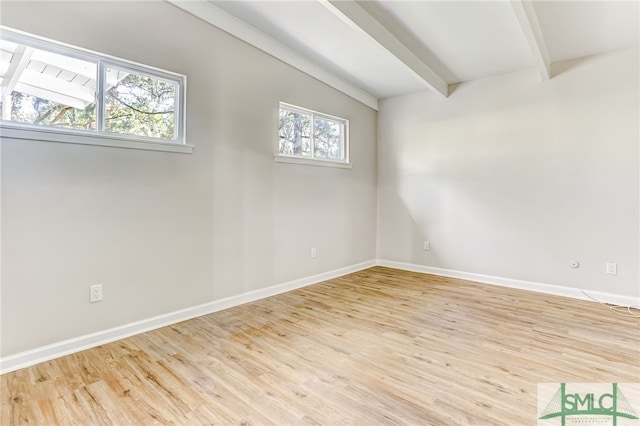 unfurnished room with lofted ceiling with beams, a healthy amount of sunlight, and light hardwood / wood-style floors