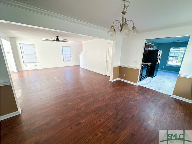 interior space with ceiling fan with notable chandelier, dark hardwood / wood-style flooring, and crown molding