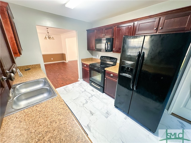 kitchen with an inviting chandelier, black appliances, sink, light wood-type flooring, and decorative light fixtures