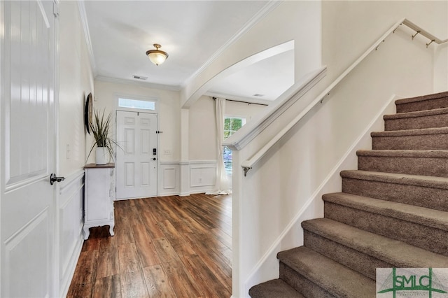 entryway with dark wood-type flooring, plenty of natural light, and crown molding