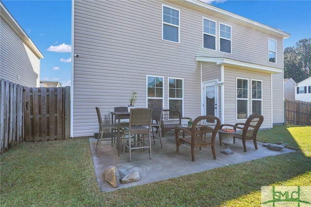 rear view of property featuring a lawn, an outdoor living space, and a patio