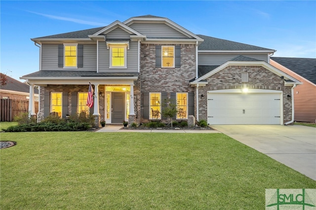 craftsman-style home featuring covered porch, a front yard, and a garage