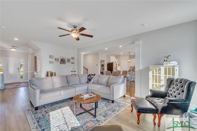 living room featuring light hardwood / wood-style flooring and ceiling fan