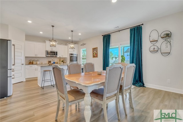 dining space with light wood-type flooring and a chandelier