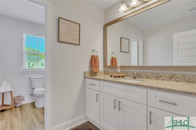 bathroom featuring hardwood / wood-style floors, vanity, and toilet