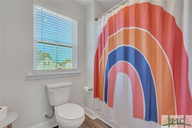 bathroom with wood-type flooring, toilet, and curtained shower