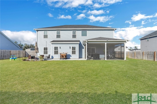 rear view of property featuring a sunroom, a patio, and a lawn