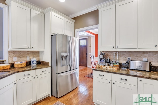 kitchen with white cabinets, light hardwood / wood-style floors, stainless steel refrigerator with ice dispenser, and ornamental molding