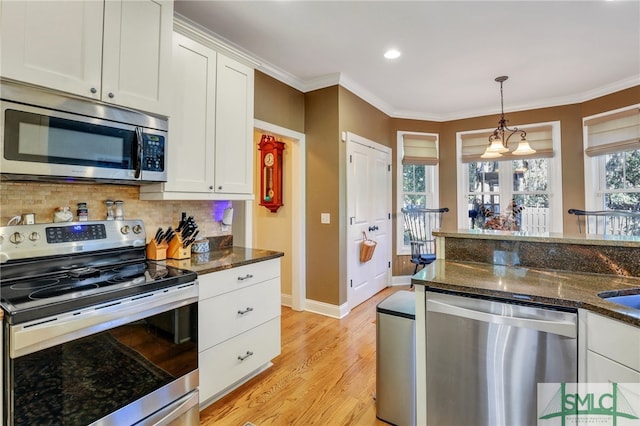 kitchen with light wood-type flooring, white cabinetry, appliances with stainless steel finishes, and tasteful backsplash