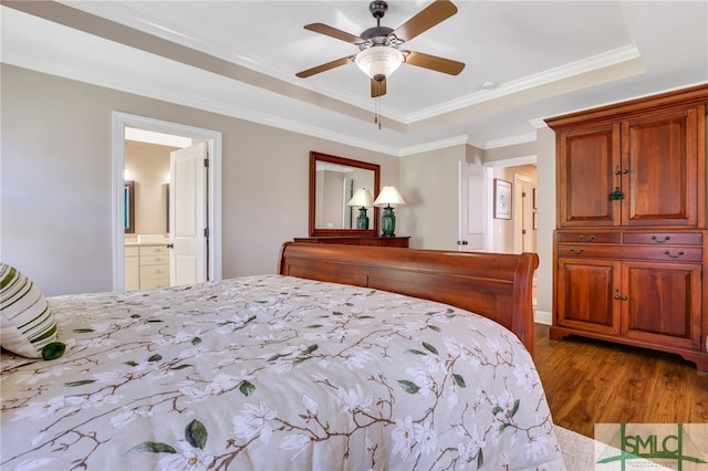 bedroom featuring ensuite bathroom, a raised ceiling, crown molding, light hardwood / wood-style flooring, and ceiling fan