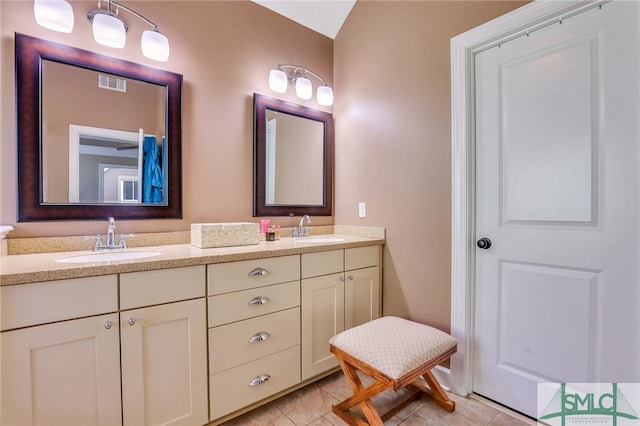 bathroom featuring tile patterned floors, vanity, and vaulted ceiling