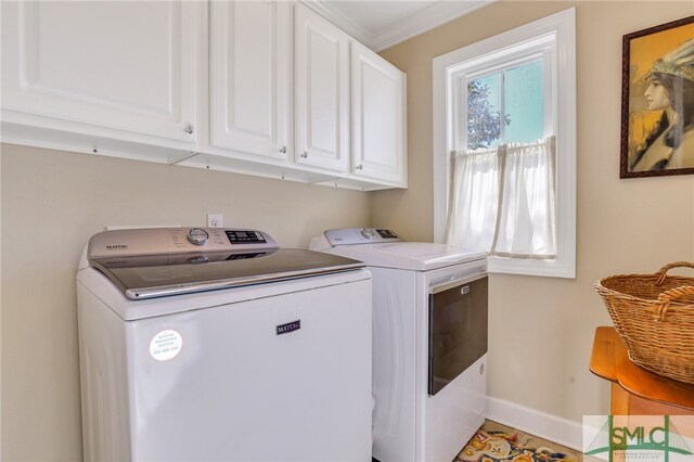 laundry area with cabinets, washer and dryer, and crown molding