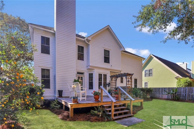 rear view of house with a deck, a pergola, and a yard