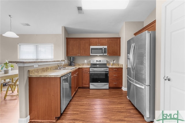 kitchen with lofted ceiling, sink, decorative light fixtures, dark hardwood / wood-style flooring, and stainless steel appliances