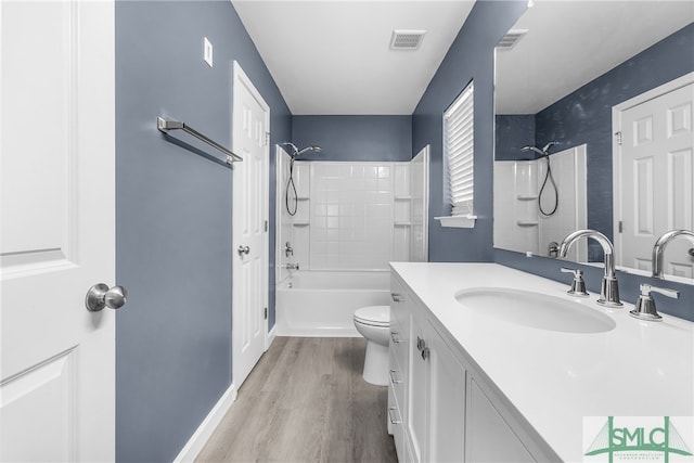 full bathroom featuring hardwood / wood-style floors, vanity, toilet, and shower / bathtub combination