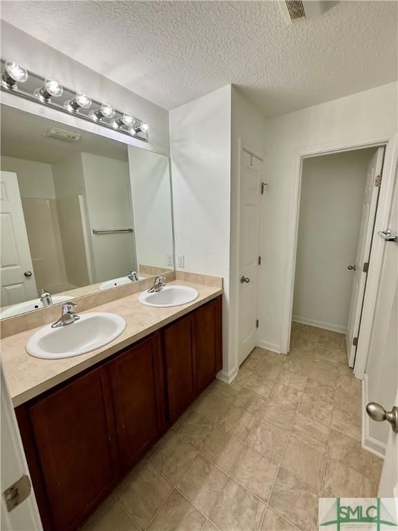 bathroom with a textured ceiling and vanity