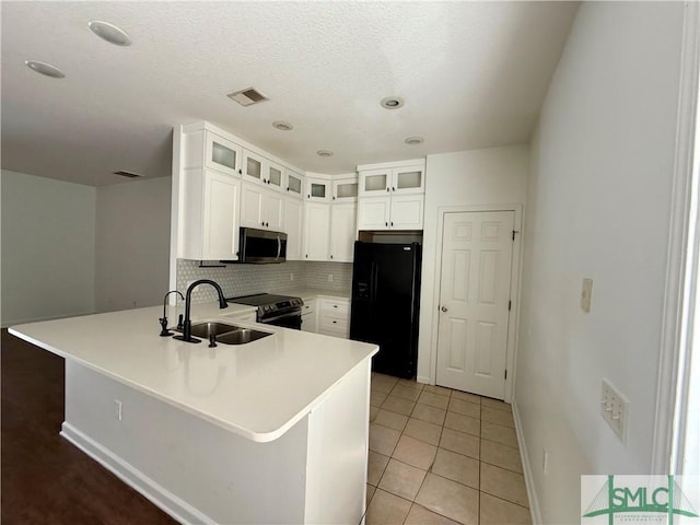 kitchen with tasteful backsplash, sink, white cabinetry, stainless steel appliances, and light tile patterned floors