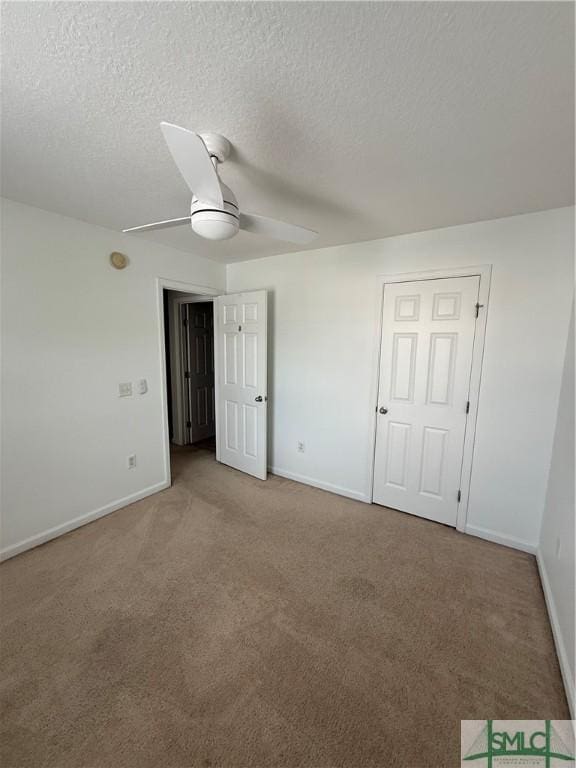 unfurnished bedroom with a textured ceiling, ceiling fan, and carpet