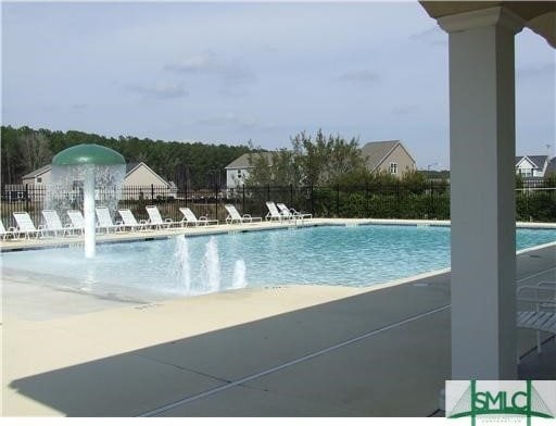 view of pool featuring pool water feature and a patio