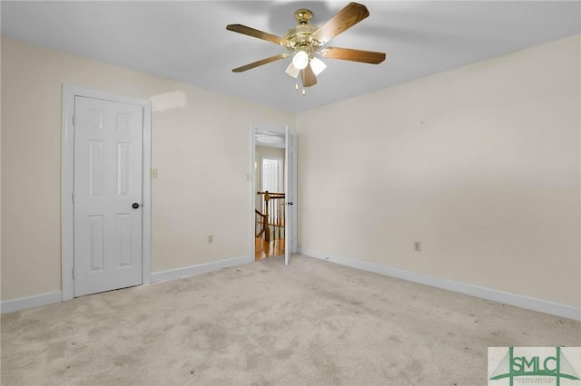 carpeted spare room with baseboards and ceiling fan