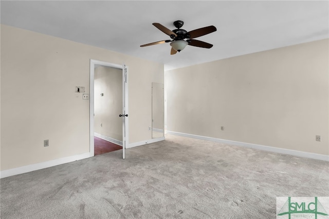 unfurnished room with ceiling fan and carpet