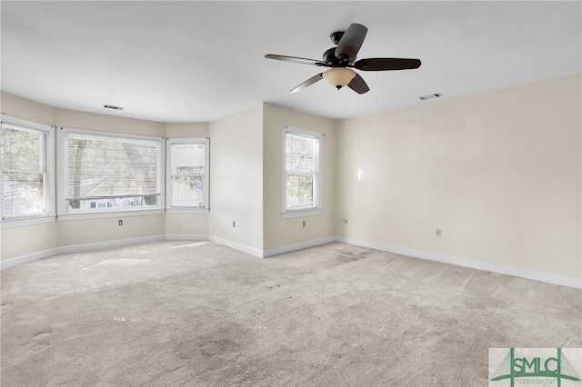 spare room with ceiling fan and light colored carpet