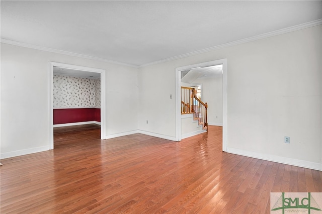 empty room featuring hardwood / wood-style flooring and ornamental molding