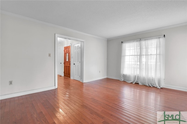 empty room featuring hardwood / wood-style flooring, ornamental molding, and a textured ceiling