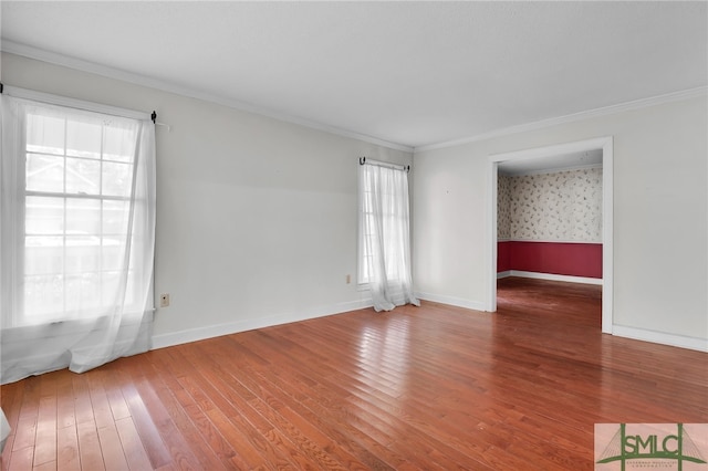 empty room featuring hardwood / wood-style floors, plenty of natural light, and crown molding