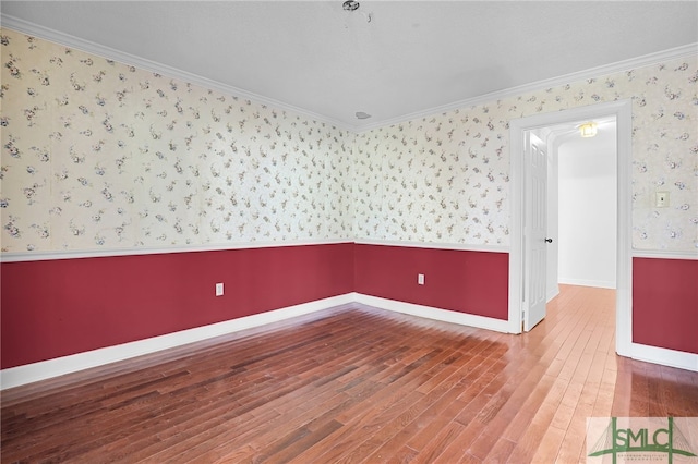 spare room with crown molding and wood-type flooring