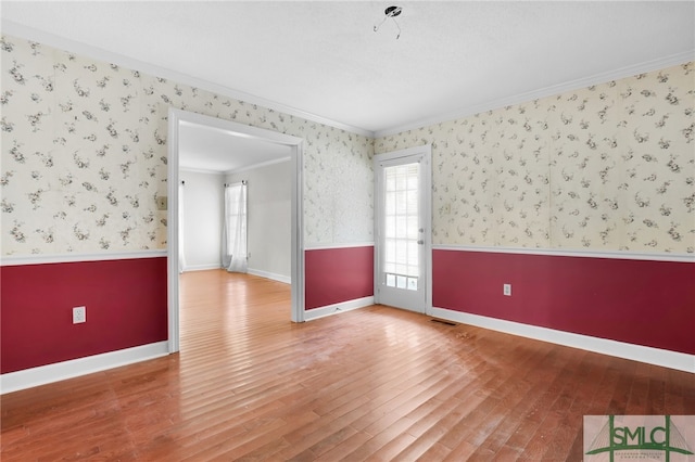 unfurnished room featuring wood-type flooring and crown molding