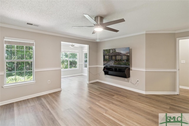 unfurnished living room with wood-type flooring, a textured ceiling, ceiling fan, and ornamental molding