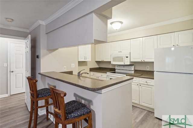 kitchen with white appliances, crown molding, kitchen peninsula, light hardwood / wood-style flooring, and white cabinetry