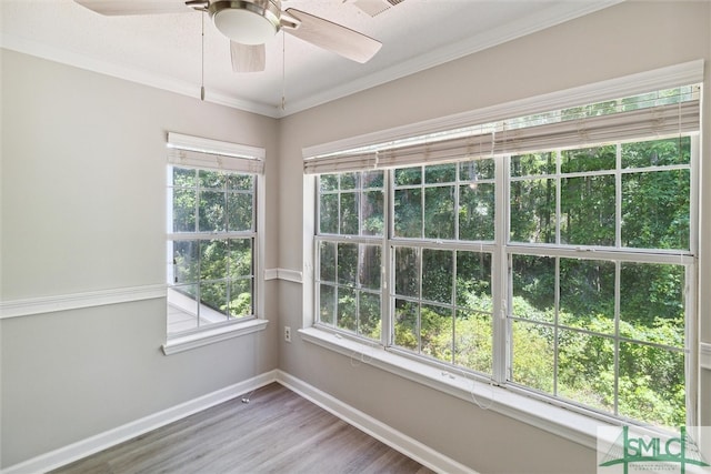 unfurnished room with hardwood / wood-style floors, ornamental molding, and a wealth of natural light