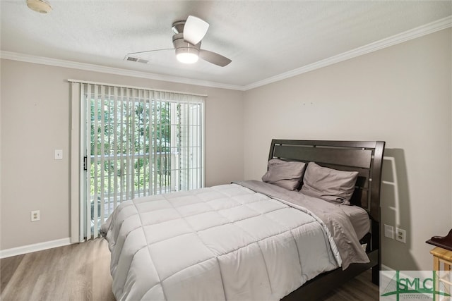 bedroom with hardwood / wood-style flooring, ceiling fan, ornamental molding, and a textured ceiling